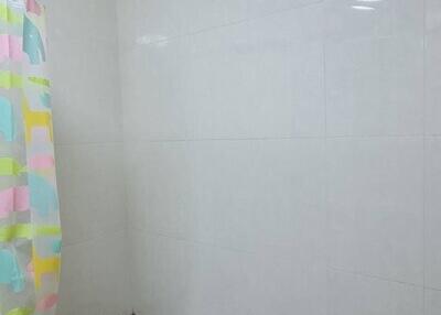 Bathroom with a shower curtain and tiled walls