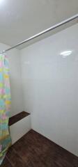 Bathroom with a shower curtain and tiled walls