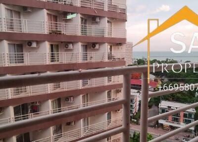 View from the balcony looking at neighboring buildings and a distant body of water