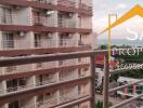 View from the balcony looking at neighboring buildings and a distant body of water