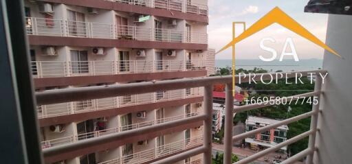 View from the balcony looking at neighboring buildings and a distant body of water