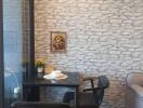 Cozy dining nook with dark wood table and chairs, decorated with a wall art piece and two potted plants.