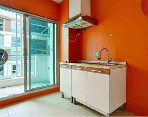 Bright kitchen with sliding glass door and basic cabinetry