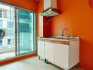 Bright kitchen with sliding glass door and basic cabinetry