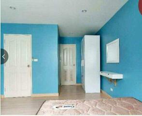 Bedroom with blue walls and white furniture