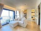 Bright living room with large windows, balcony access, plush sofa, chandelier, and built-in shelving