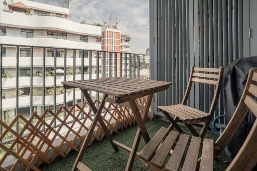 Small balcony with table and chairs overlooking cityscape