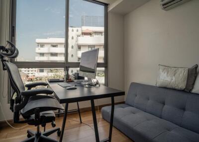 Modern home office with a desk, chair, and couch