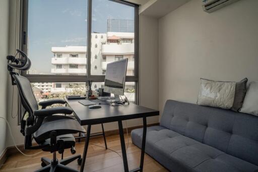 Modern home office with a desk, chair, and couch