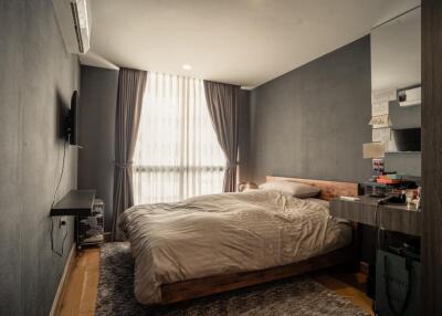 Modern bedroom with bed, curtains, and wall-mounted TV