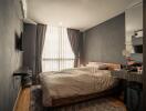 Modern bedroom with bed, curtains, and wall-mounted TV