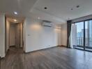 Empty living room with large windows and air conditioning unit