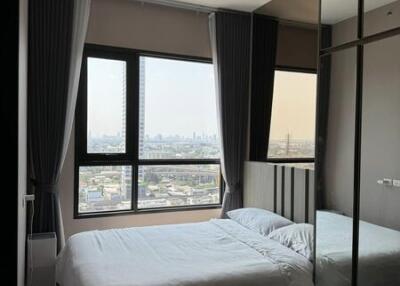 Modern bedroom with large windows and a city view