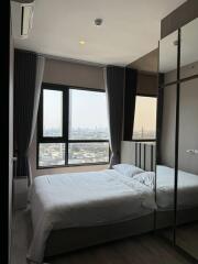 Modern bedroom with large windows and a city view