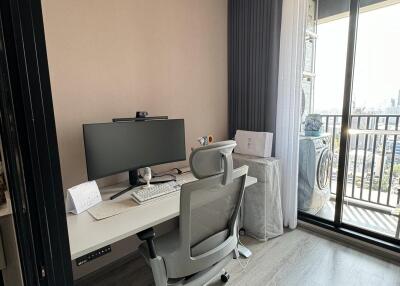 Home office with desk, chair, computer setup and large window