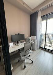 Home office with desk, chair, computer setup and large window