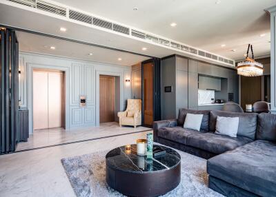 Modern living room with sectional sofa, chandelier, and marbled coffee table