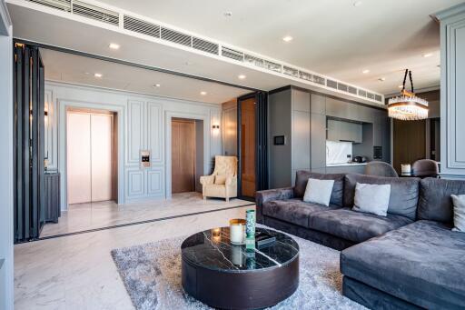 Modern living room with sectional sofa, chandelier, and marbled coffee table