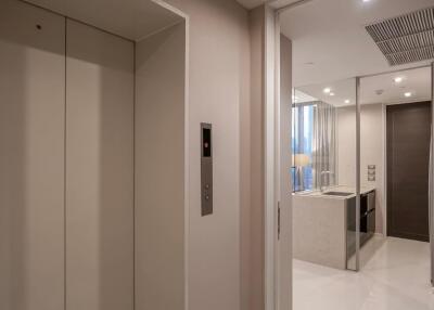 Entry hallway with elevator and view into a modern kitchen