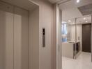 Entry hallway with elevator and view into a modern kitchen