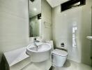 Modern bathroom with mirror, sink, toilet, and glass-enclosed shower