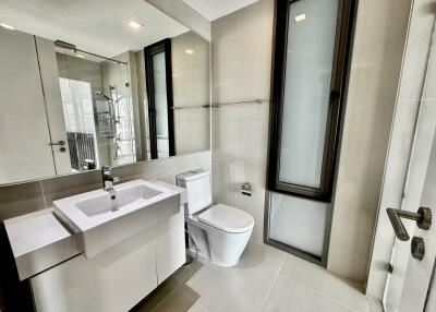 Modern bathroom with white sink, toilet, and glass-enclosed shower