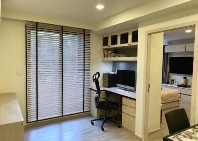 Modern home office with desk, shelves, and computer setup