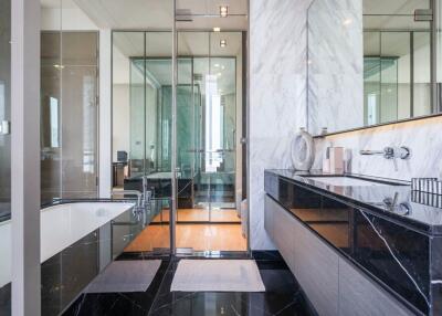 Modern bathroom with glass shower, bathtub, and dual sink vanity