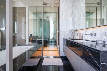 Modern bathroom with glass shower, bathtub, and dual sink vanity