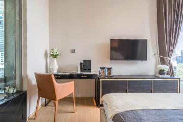 Modern bedroom with a desk, wall-mounted TV, and large window