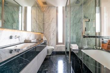 Modern bathroom with marble walls and black countertops