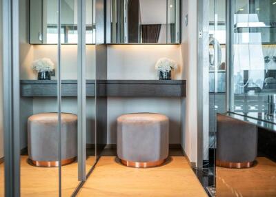 Modern bedroom vanity area with mirror and stools