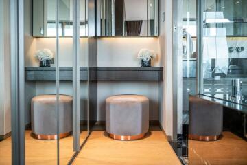 Modern bedroom vanity area with mirror and stools