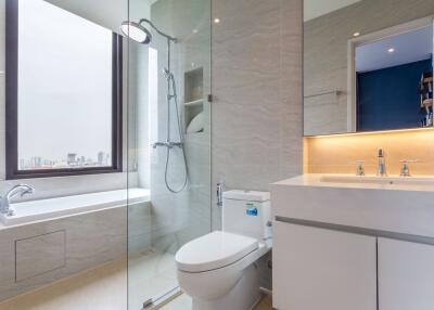 Modern bathroom with glass shower, bathtub, and sleek sink