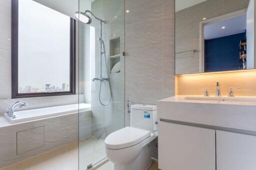 Modern bathroom with glass shower, bathtub, and sleek sink