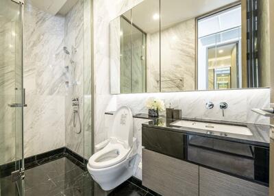 Modern bathroom with glass shower, toilet, and sink