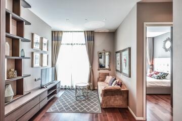 Living room with a TV, sofa, coffee table, large window, and bedroom in the background