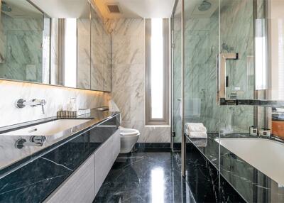 Luxurious bathroom with modern fixtures, marble countertops, and glass shower