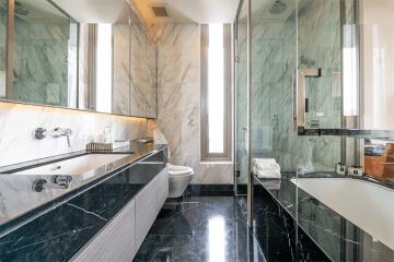 Luxurious bathroom with modern fixtures, marble countertops, and glass shower