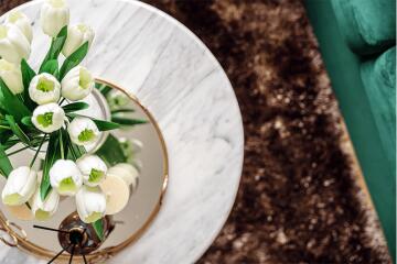 Marble table top with white tulips and green couch