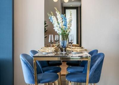 Modern dining room with blue chairs and decorative chandelier