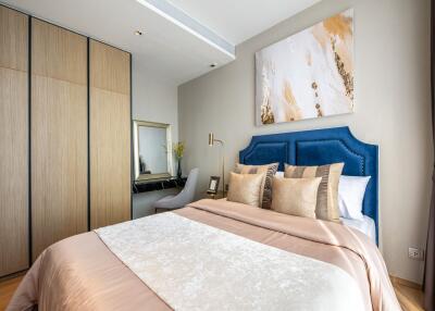 Modern bedroom with wooden wardrobe, stylish bed, and wall art