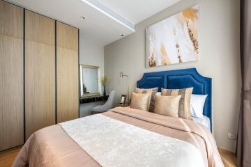 Modern bedroom with wooden wardrobe, stylish bed, and wall art