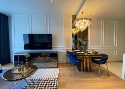 Elegant living room and dining area with chandelier and television