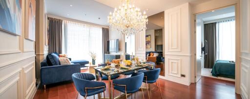 Elegant living and dining area with modern decor and chandelier