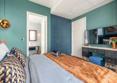 Well-decorated bedroom with attached bathroom, blue and green color scheme, modern decor and furniture