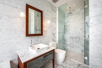 Modern bathroom with marble walls and glass shower