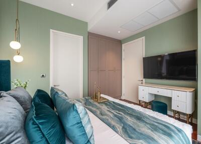 Modern bedroom with green accents and a TV