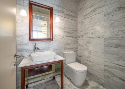 Modern bathroom with marble walls and a rectangular mirror