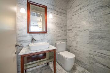 Modern bathroom with marble walls and a rectangular mirror